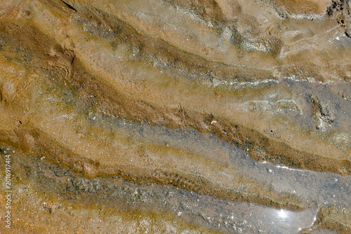 Photography Detailed close-up of wet beach sand, natural textures and patterns created by water
