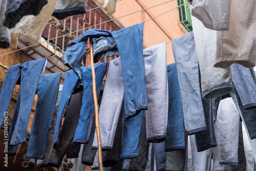 Photography After the ring-dyeing process jeans trousers are hanging in the sun to dry in a street for lasting colour