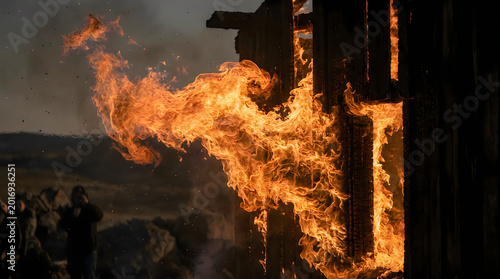 Violent flames erupting from wooden structure during intense house fire