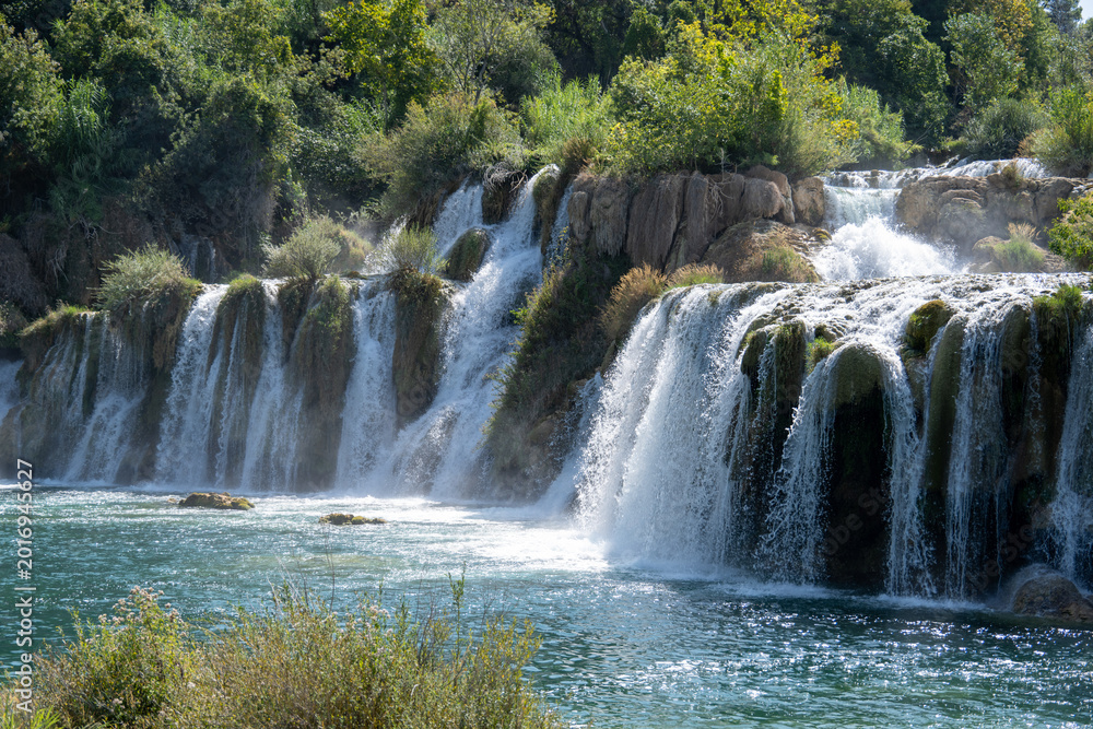 Fototapeta premium Waterfall cascades into river pool, Krka National Park, Croatia