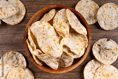 Cuadro en lienzo Crispy tempeh chips fill a small wooden bowl presented from a top down perspecti
