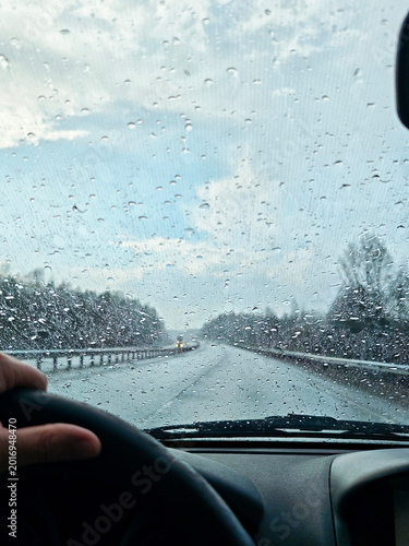 Driving through rain on a road trip with blurred view from the windshield