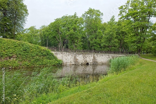 Bild auf Leinwand Scenic stone bridge situated in a lush, green park environment in cloudy summer weather, Kuressaare, Saaremaa, Estonia, Europe