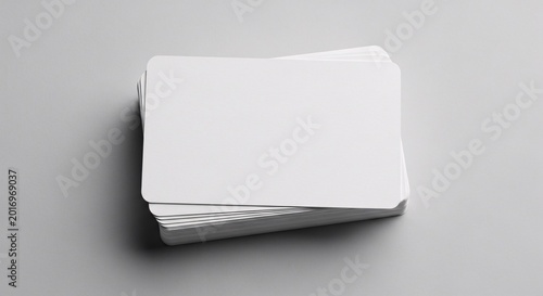 Stack of blank white business cards on gray background with copy space