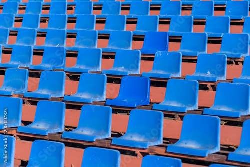 Valokuva Empty blue plastic stadium seats are arranged in rows on a wooden bleacher struc