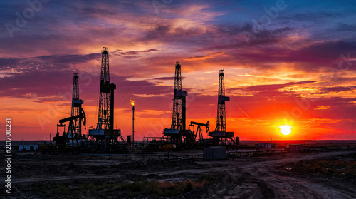 Background oil pumps mining natural gas at sunset concept. Oil rigs at sunset, showcasing the beauty of industrial landscapes.