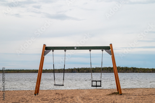 Children's swing on the beach of a lake in Finland.