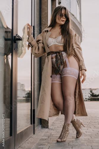 Obraz na płótnie Lingerie woman trenchcoat posing outdoors in fashionable underwear and a beige c