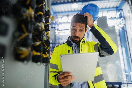 Obraz na płótnie Industrial worker supervising machinery operations in modern production plant