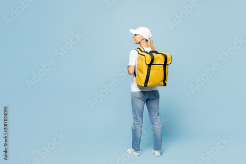 Full body delivery employee woman wear white cap T-shirt uniform yellow thermal food bag backpack workwear work as dealer courier isolated on plain pastel light blue background studio Service concept