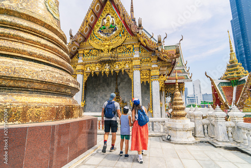Foto Back view of a young family with a child visiting the ornate Wat Hua Lamphong te