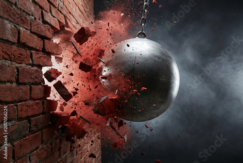 Heavy steel wrecking ball crashing through red brick wall