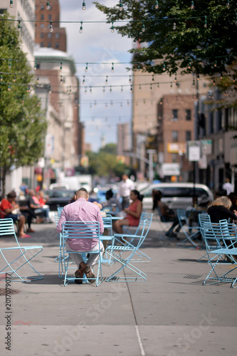 Tranquil Urban Setting Featuring Lone Diner Among Colorful Outdoor Furniture new york