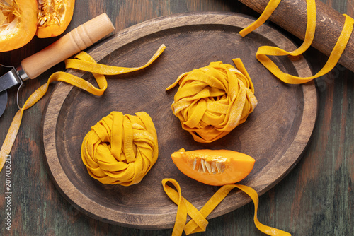 Konstfotografi Homemade uncooked pumpkin tagliatelle or fettuccine noodles on a wooden board