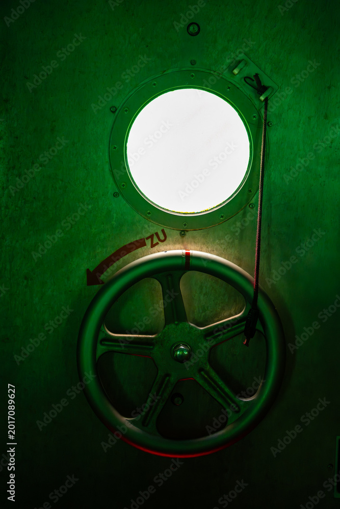 Obraz premium Metal hatch wheel and porthole inside the diving gondola at Sellin Pier on Rugen island, Germany. Nautical engineering and underwater technology concept.