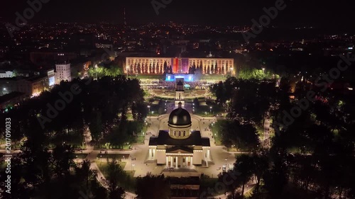 Symmetrical night aerial ascent above Chisinau Cathedral Park and central square