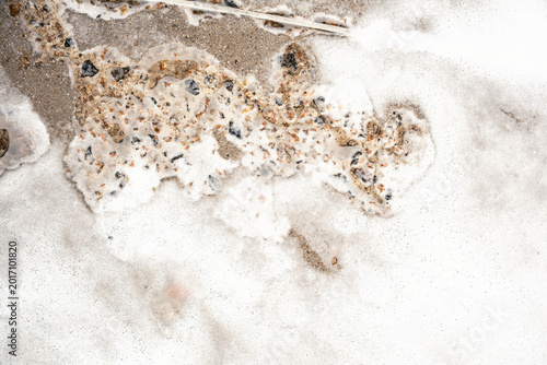Foto White foam covers ground with vertical flowing streaks creating natural abstract
