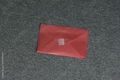 Envelope placed on gray carpet in indoor setting during daytime
