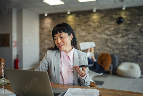 Foto Businesswoman talking on speakerphone collaborating in office setting