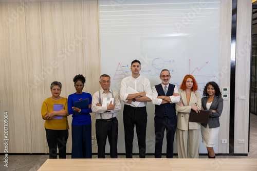 Foto Portrait of a diverse, multi-ethnic corporate business team standing confidently together in a modern office meeting room in front of a whiteboard