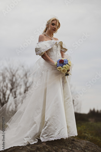 Bride with bouquet outdoors. Lifestyle and wedding concept.
