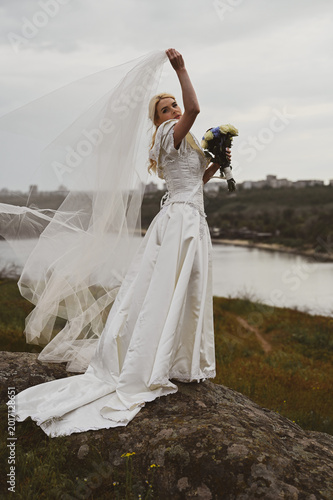 Bride with bouquet outdoors. Lifestyle and wedding concept.