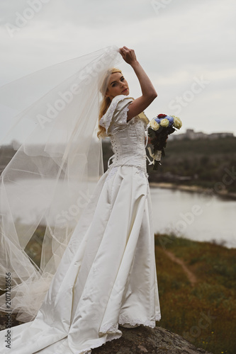 Bride with bouquet outdoors. Lifestyle and wedding concept.
