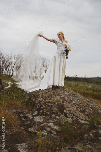 Bride with bouquet outdoors. Lifestyle and wedding concept.