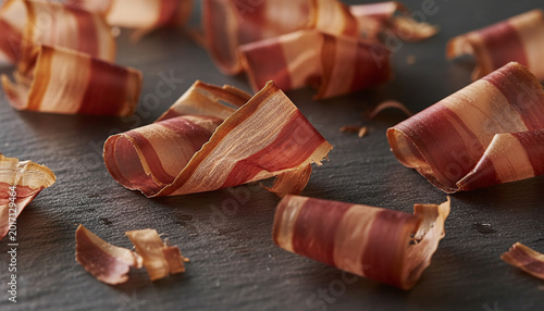 Translucent Katsuobushi dried bonito flakes macro on dark slate