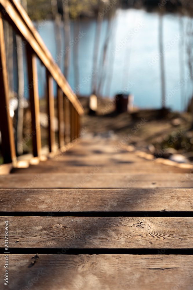 Fototapeta premium Rustic wooden steps in a Nordic forest landscape leading to the riverbank,