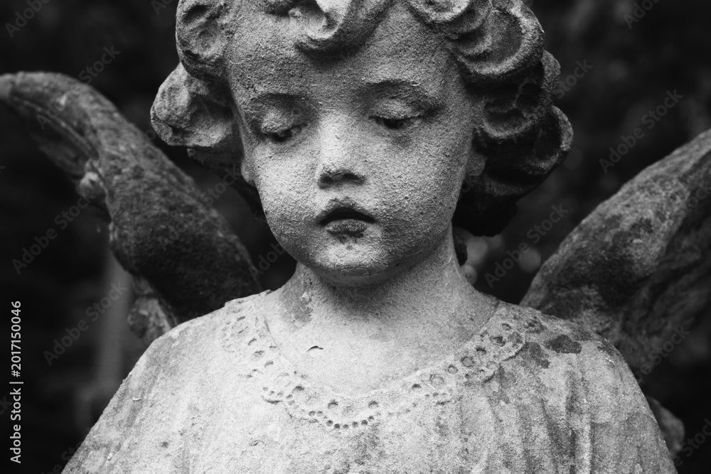 Fototapeta premium Vintage cherub sculpture symbolizing innocence and remembrance