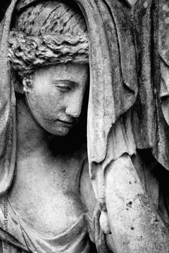 Fototapeta premium Sad angel statue in cemetery symbolizing grief and eternal mourning