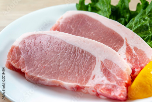 Obraz na płótnie 豚肉ステーキの生肉が白い皿に盛られた調理前の食材