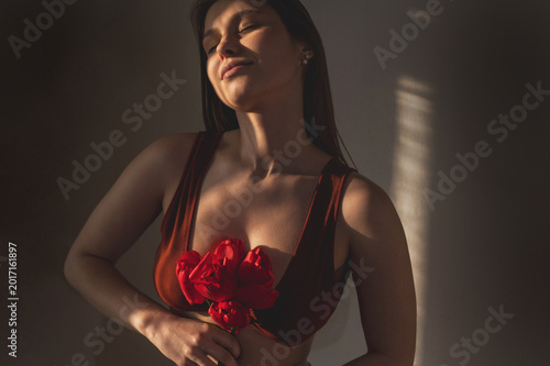 Foto A blurry portrait of an attractive young woman holding a red tulip