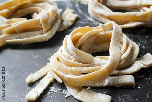 Canvastavla close up of homemade raw fettuccine pasta on a black background