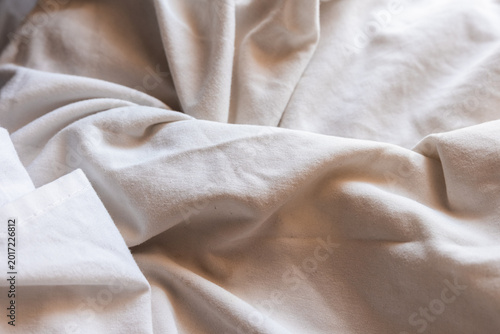 Foto Close-up of soft, wrinkled fabric texture in light beige color