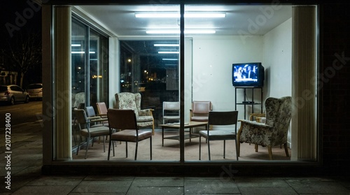 Empty chairs in care home common room at night — collective solitude, aging concept