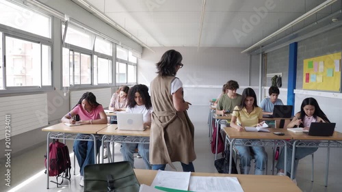 High school teacher walking through classroom of diverse students