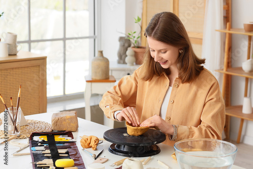 Female sculptor shaping cla...