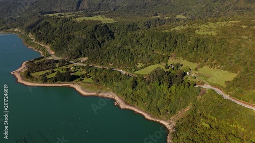 Cinematic Perspective of Drone Flying Over Water Toward Forest Mountain Road