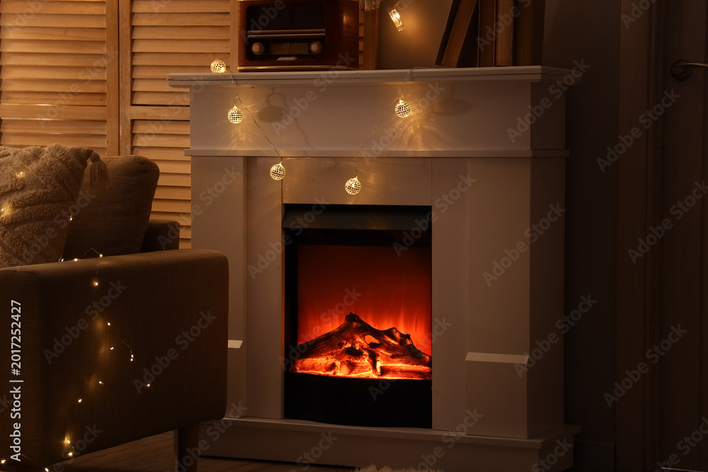 Obraz premium Fireplace with glowing lights in dark living room