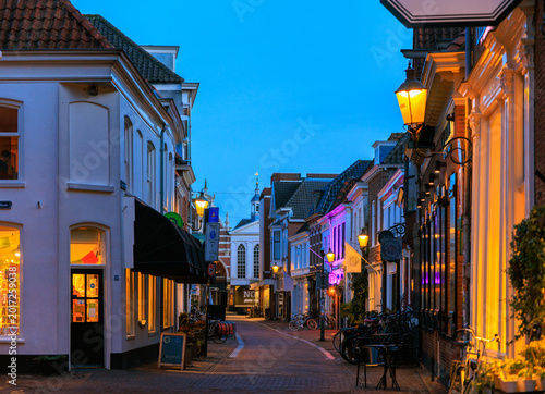 Foto European dutch old town commercial street at twilight with warm lighting on,  glowing from window