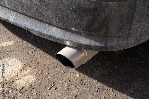 Photos A close view of a car exhaust pipe shows dirt and grime on the outside