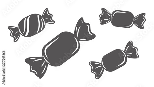 Bild auf Leinwand Four dark gray wrapped candies with white highlights white candy sweet treat