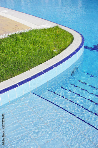Blue pool filled with water in Summer