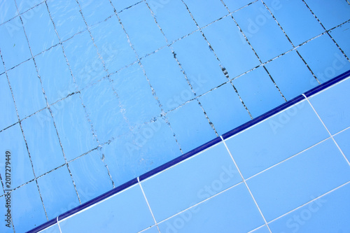 Blue pool filled with water in Summer