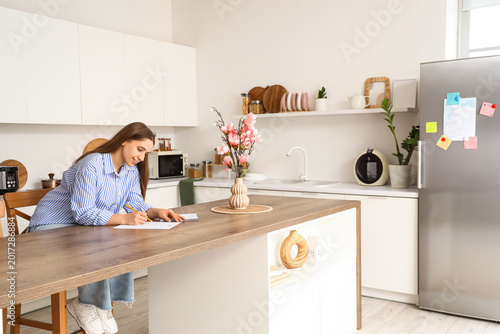 Young woman making to-do li...