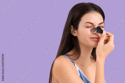 Young woman removing nose p...