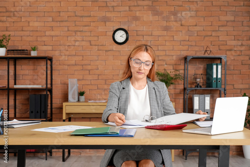 Canvastavla Female accountant in eyeglasses working with folder at workplace in office