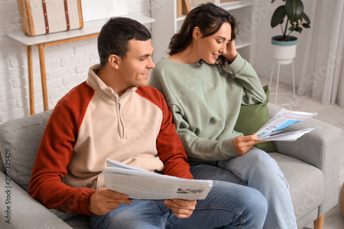 Young couple with newspaper...